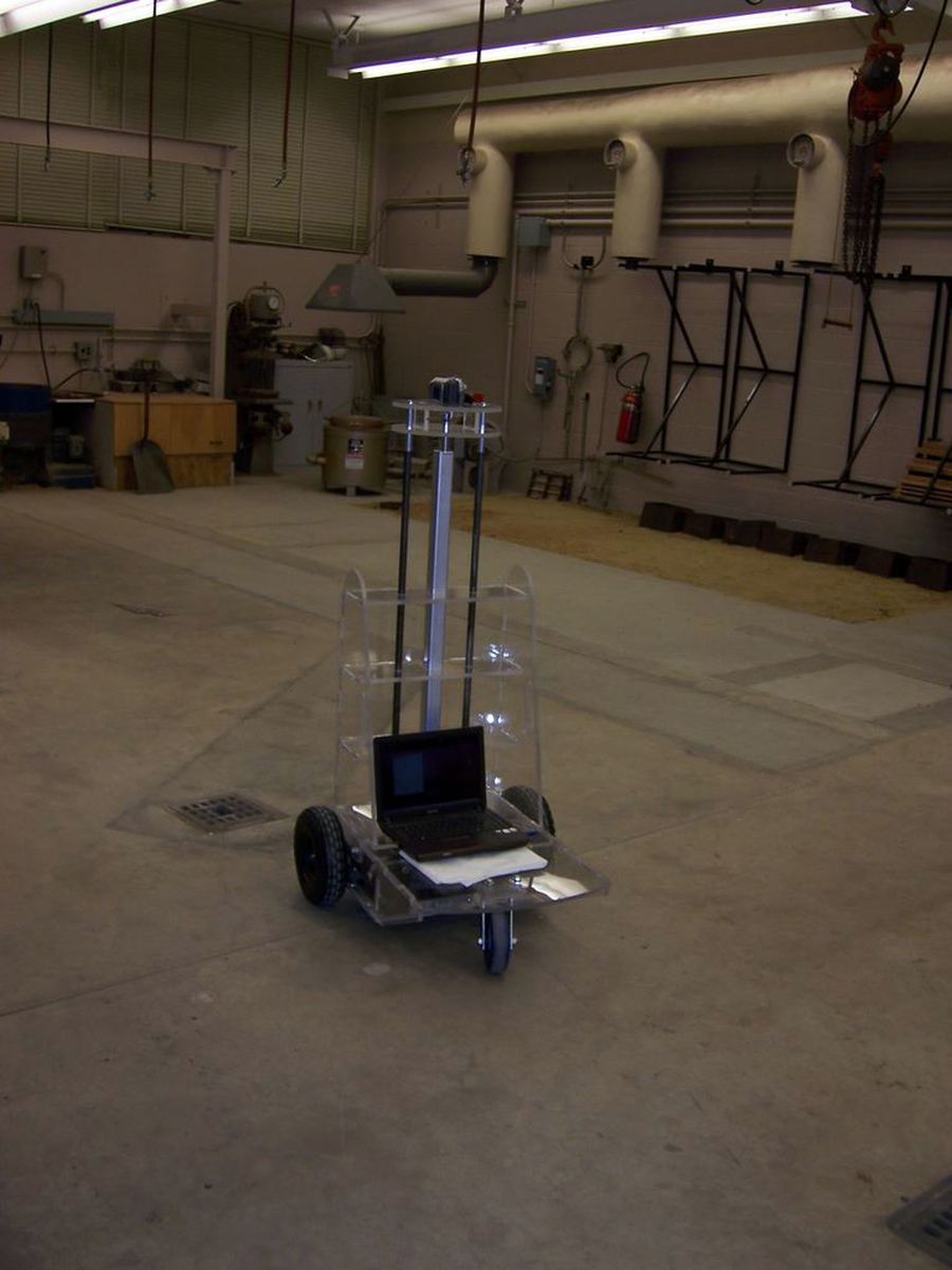 The cart under test on a workshop floor, a laptop mounted at its base to drive it.