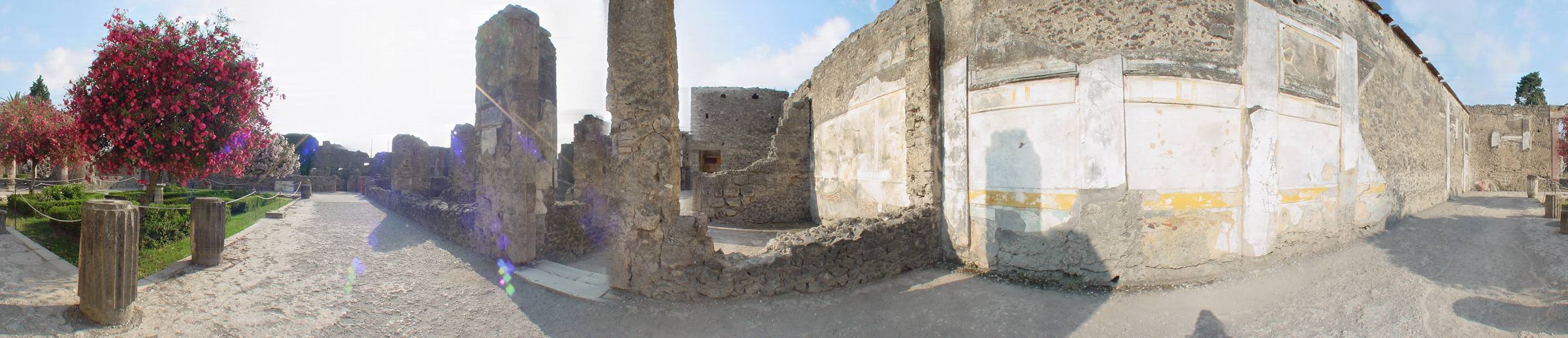 A 360° panorama of the House of the Faun at Pompeii: a garden with a red flowering tree, columns and plastered walls around an atrium.